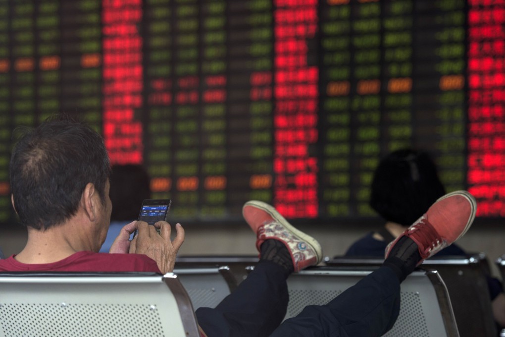 An investor puts up his feet while monitoring stock prices in China's volatile markets this week. The markets in the country are closed Thursday for a holiday. Photo: AFP