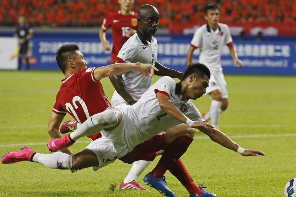 Hong Kong's Lee Chi-ho (right) goes down in the tackle of China's Yu Dabao during their World Cup qualifier in Shenzhen. Hong Kong held China to a 0-0 draw. Photo: AP