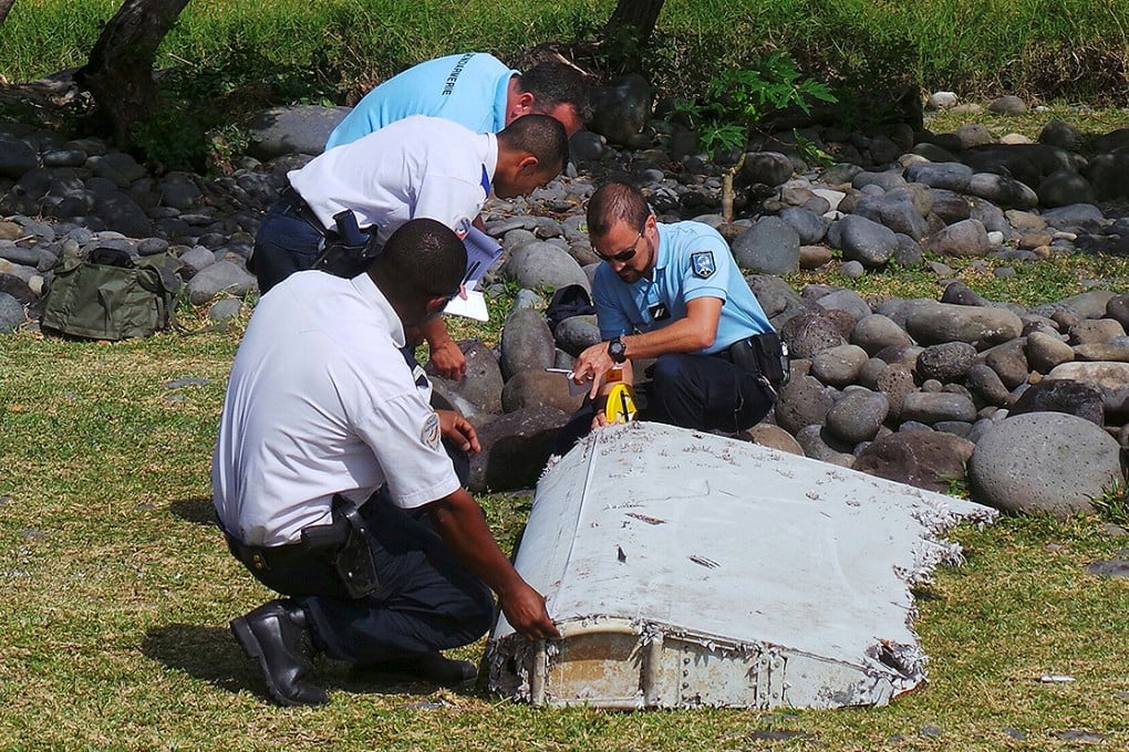 French gendarmes and police inspecting a large piece of plane debris which was found on the beach in Saint-Andre on the French Indian Ocean island of La Reunion. Photo: Reuters