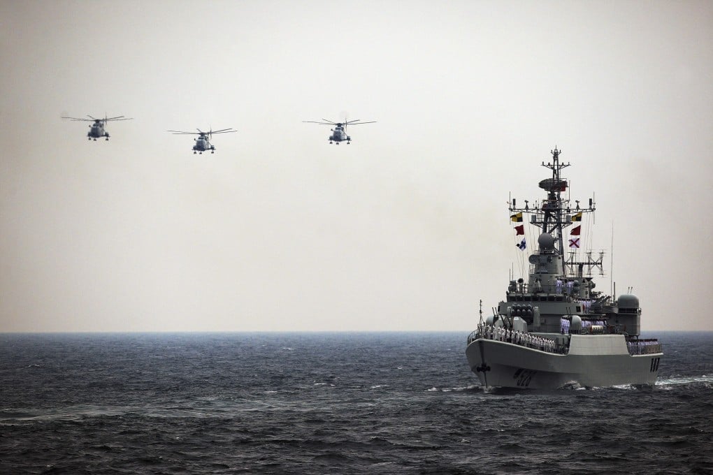 Helicopters accompany the Chinese Jiangwei II naval frigate "Mianyang" during an international fleet review in Qingdao in 2011. Photo: Reuters