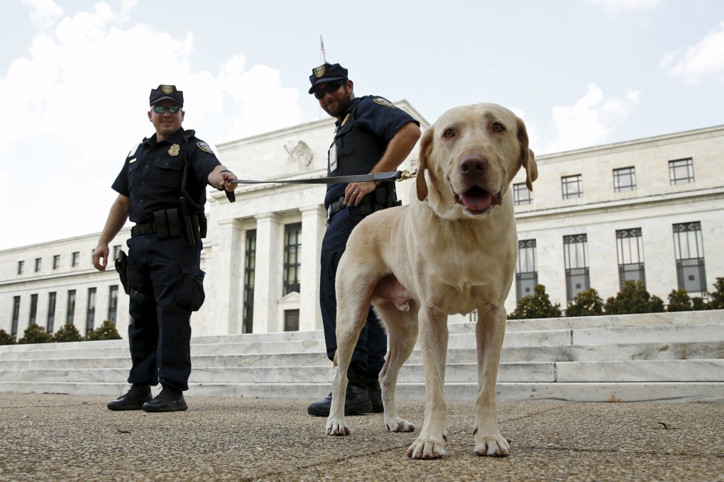 Police officers and a dog stand guard outside the US Federal Reserve building in Washington. Photo: Reuters