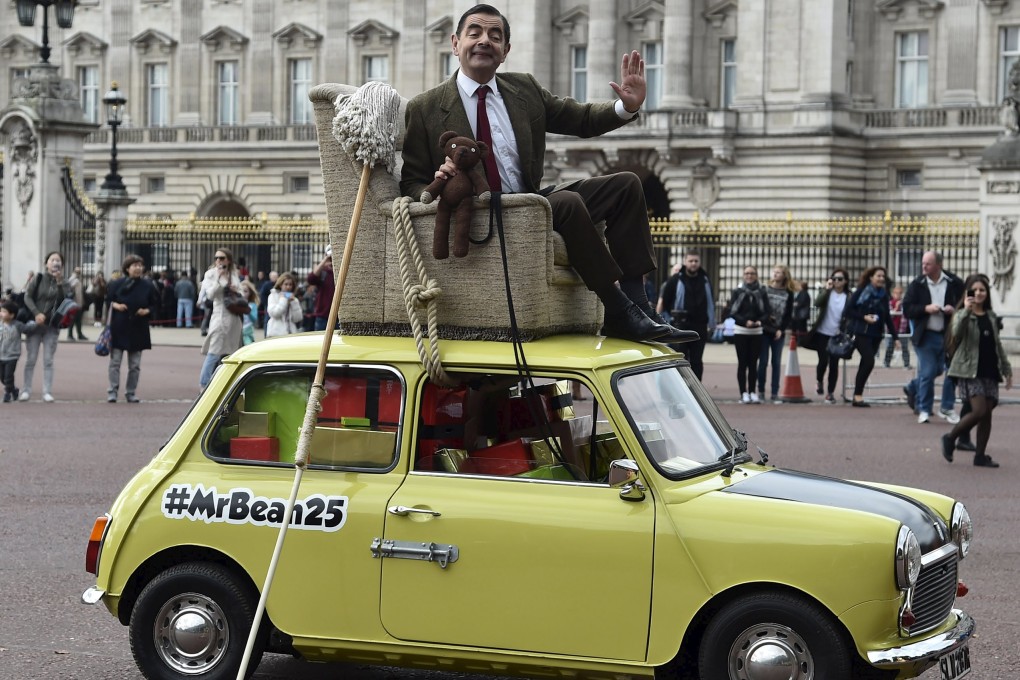 British comedian Rowan Atkinson, in character as 'Mr Bean', poses on a Mini car besides Buckingham Palace in central London. Photo: Reuters