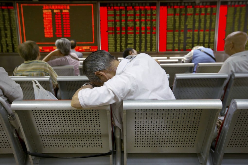 A weary investor takes a nap while monitoring stock prices at a brokerage in Beijing. Photo: AP