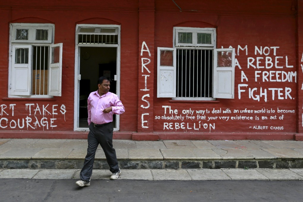 A staff member walks past a graffiti-painted wall of an administrative office at the Film and Television Institute of India  in Pune. Photo: Reuters