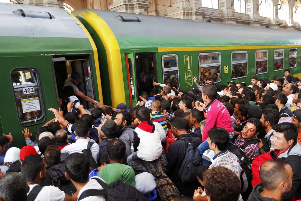 Pushing, shoving and fighting, hundreds of refugees try to get on board one train at the Keleti railway station in Budapest, Hungary, after the station reopened. Photo: Reuters