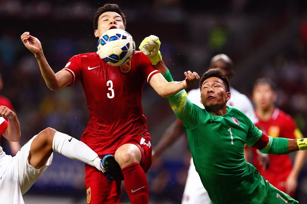Hong Kong keeper Yapp Hung-fai tries to punch the ball away from China's Mei Fang during their qualifying match in Shenzhen. Photo: AFP