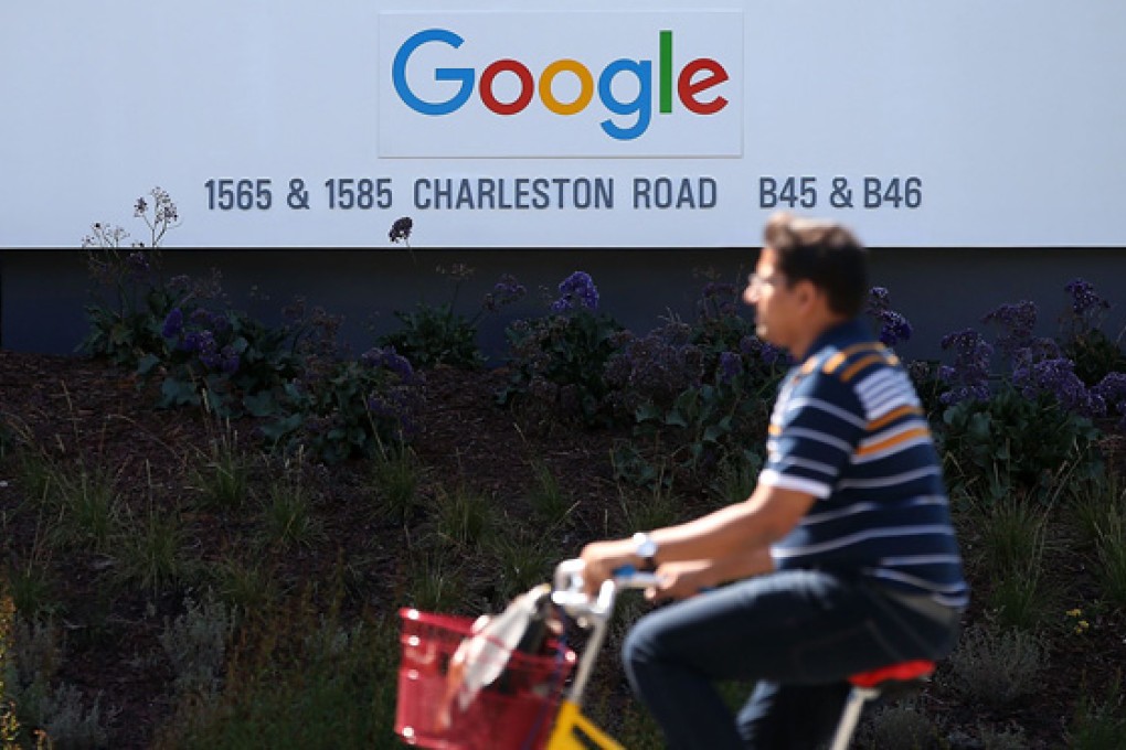 A man cycles past the new Google logo displayed on a sign outside the internet giant's headquarters. Photo: AFP
