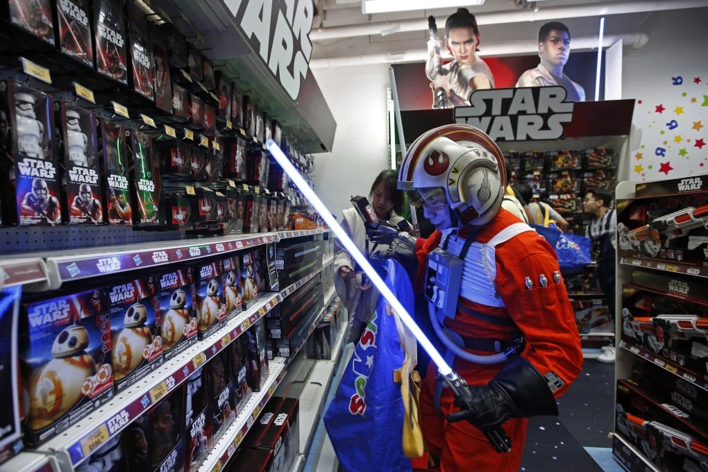 A fan dressed as a Star Wars character shops at a toy store at the midnight in Hong Kong. Photo: AP