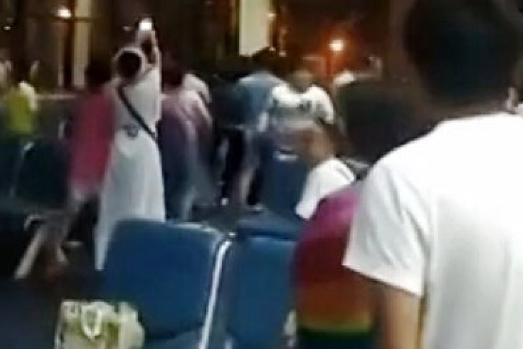 Dozens of mainland tourists, angered by news of a 10-hour flight delay, refused to leave the departure hall at Bangkok's Don Mueang Airport on Friday night. Photo: Video still
