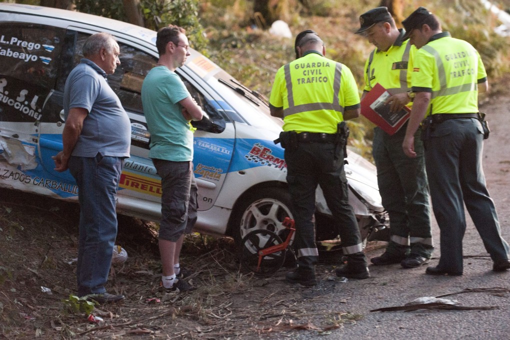 Rescue workers at the scene where at least six people died in a crash during a rally in A Coruna, Spain. Photo: EPA