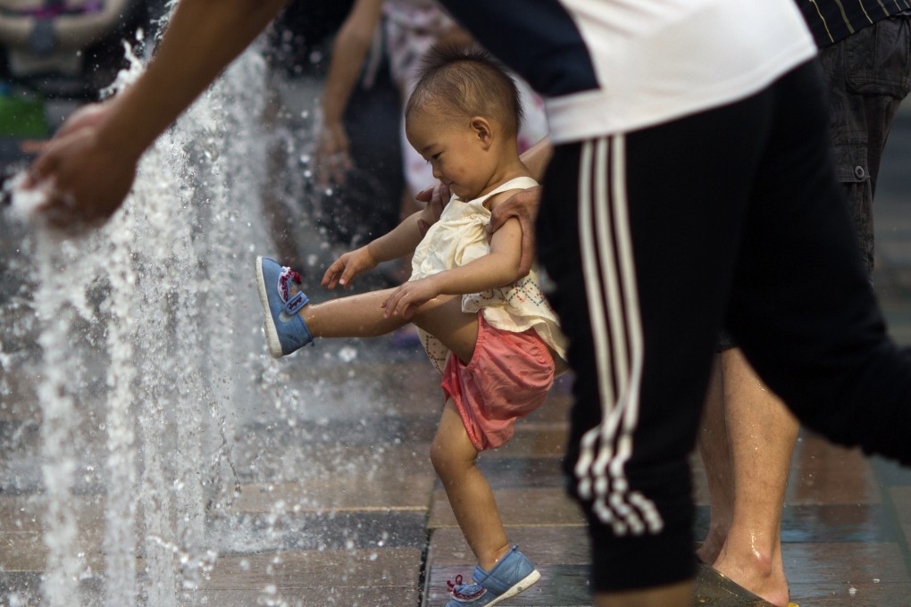 A child plays near a water fountain at a mall in Beijing. Photo: AP