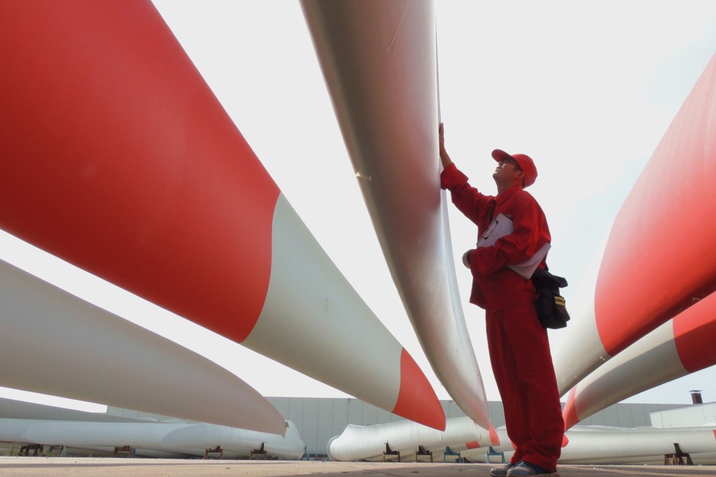 A worker checks the quality of the blades of wind turbines in a factory in Lianyungang, Jiangsu province. Photo: AFP