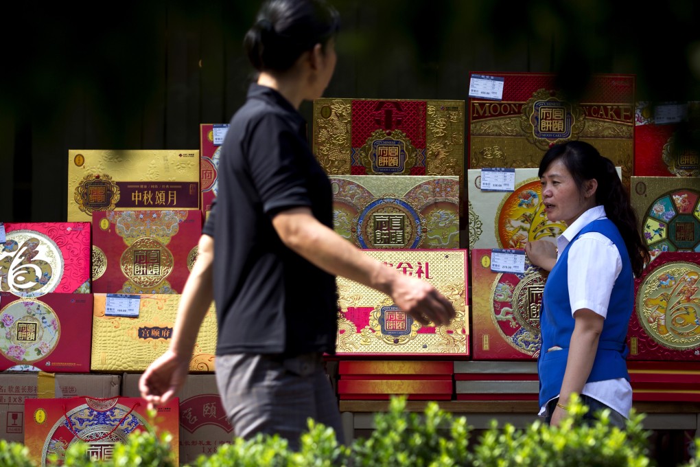 A pedestrian walks past a mooncake display in Beijing. The CCDI has set up a webpage for people to report on officials using the Mid-Autumn Festival as an excuse to waste public money. Photo: AP