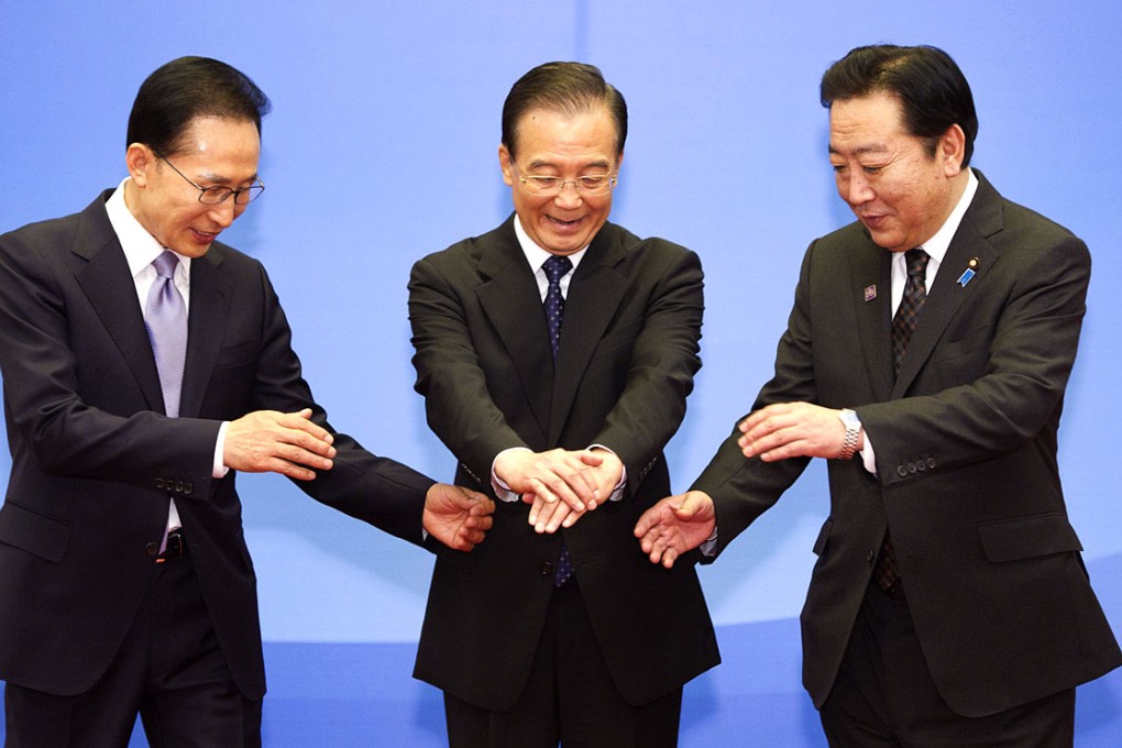 Chinese Premier Wen Jiabao (centre), President of the Republic of Korea (ROK) Lee Myung-bak (left) and Japanese Prime Minister Yoshihiko Noda (right) prepare to shake hands during the Fifth Trilateral Summit Meeting among China, the ROK and Japan at the Great Hall of the People in Beijing on May 13, 2012. Photo: Xinhua