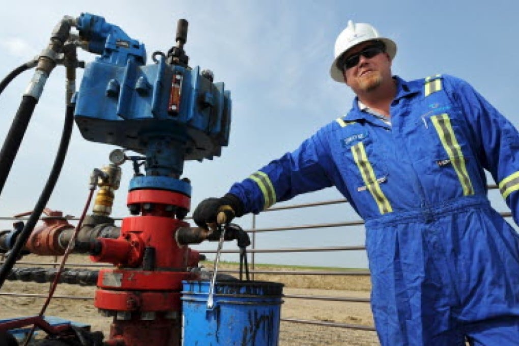 Dwayne Roy checks a tap at an active well site near Lloydminster, Saskatchewan. Photo: Reuters