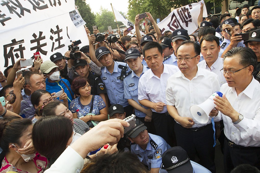 Tianjin Binhai New Area Communist Party boss Zong Guoying (right) speaks to protesting homeowners on August 19. Photo: Simon Song