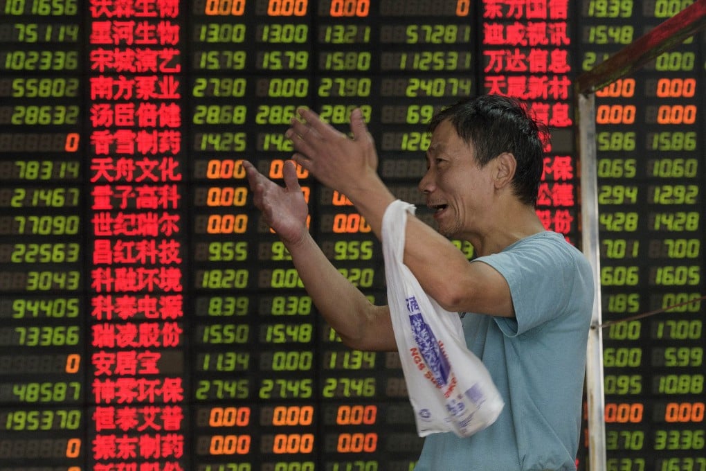 An investor reacts in front of screens showing stock market movements at a brokerage house in Shanghai, China. Photo: AFP