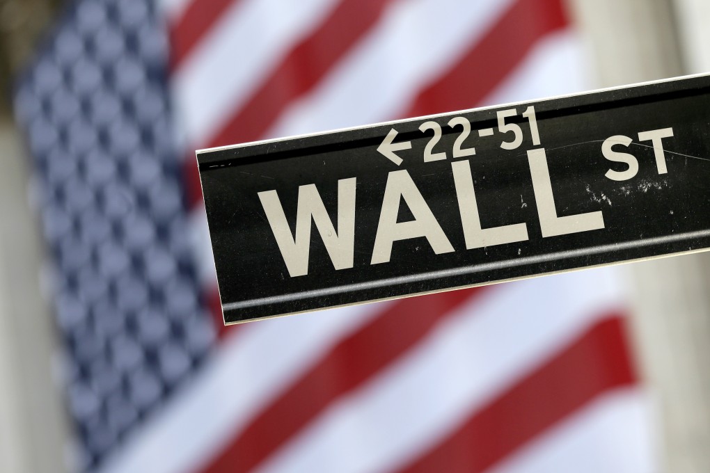 The Wall Street sign is framed by an American flag hanging on the facade of the New York Stock Exchange. Photo: AP