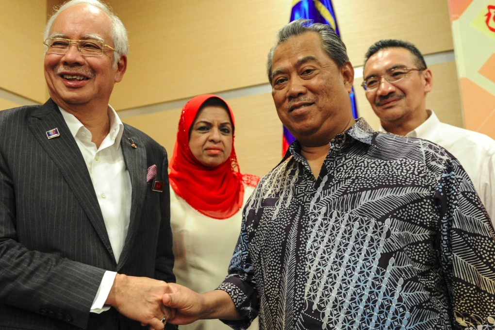 Malaysia's Prime Minister Najib Razak (left) shakes hands with his former deputy prime minister Muhyiddin Yassin (front R) after the Umno's supreme council monthly meeting. Photo: AFP