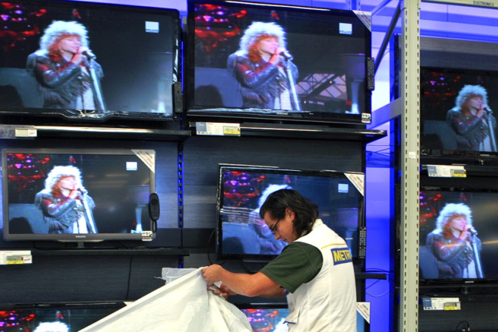An employee unwraps boxes containing flatscreen TVs at a Metro AG Cash & Carry store in Weiterstadt, Germany. Photo: Bloomberg