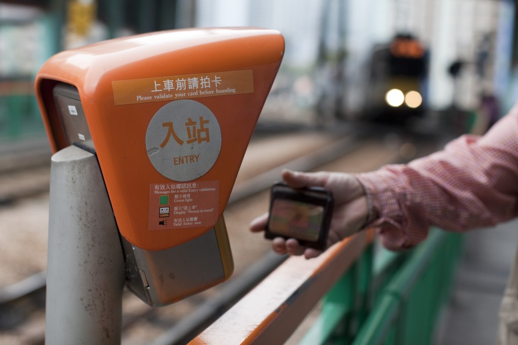 A commuter swipes his Octopus card before boarding an MTR light rail train in the Tin Shui Wai area of Hong Kong. Photo: Bloomberg