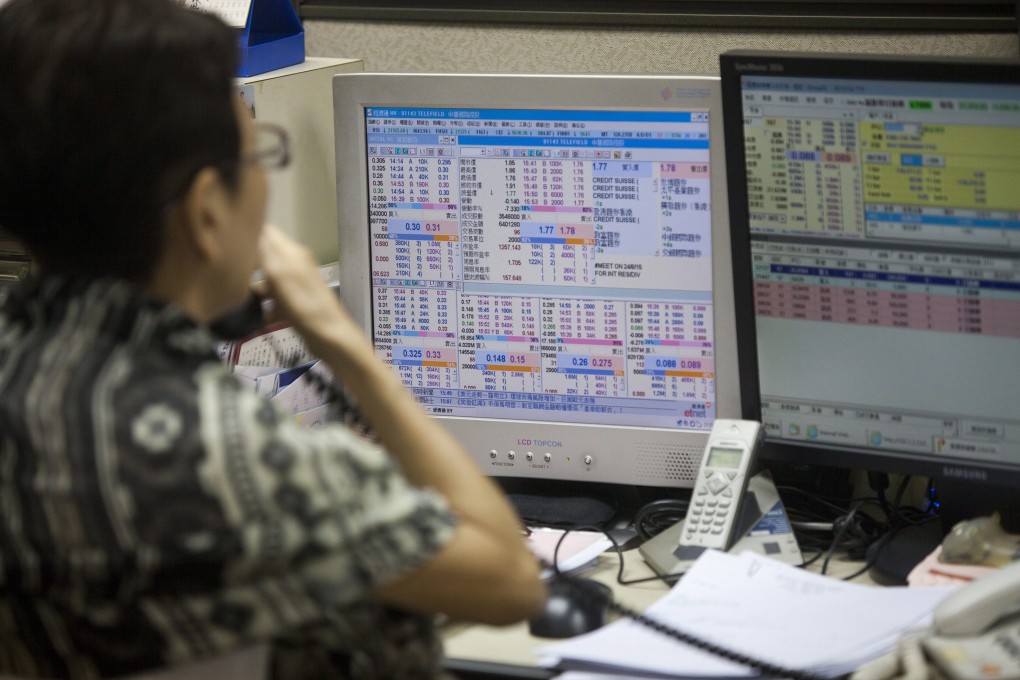 A stock broker operates at a trading house as the Hang Seng Index falls during Thursday's action. Photo: EPA