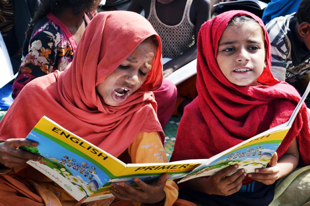 Pakistani children read English books at school in Lahore. Pakistan has six major languages, but English has been preferred for laws, court orders, and all other forms of official communication by the ruling elite. Photo: AFP