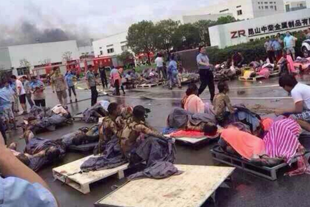 Rescuers help the victims of an explosion at the gate of a factory in Kunshan, Jiangsu province on August 2, 2014. Dust in a polishing workshop caught fire and the blast ripped through the facility. Photo: Reuters