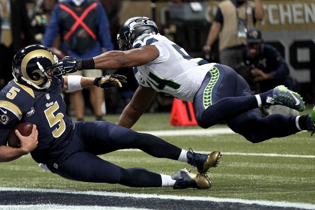 St. Louis Rams quarterback Nick Foles, left, scores on a 1-yard run past Seattle Seahawks linebacker Bobby Wagner Photo: AP
