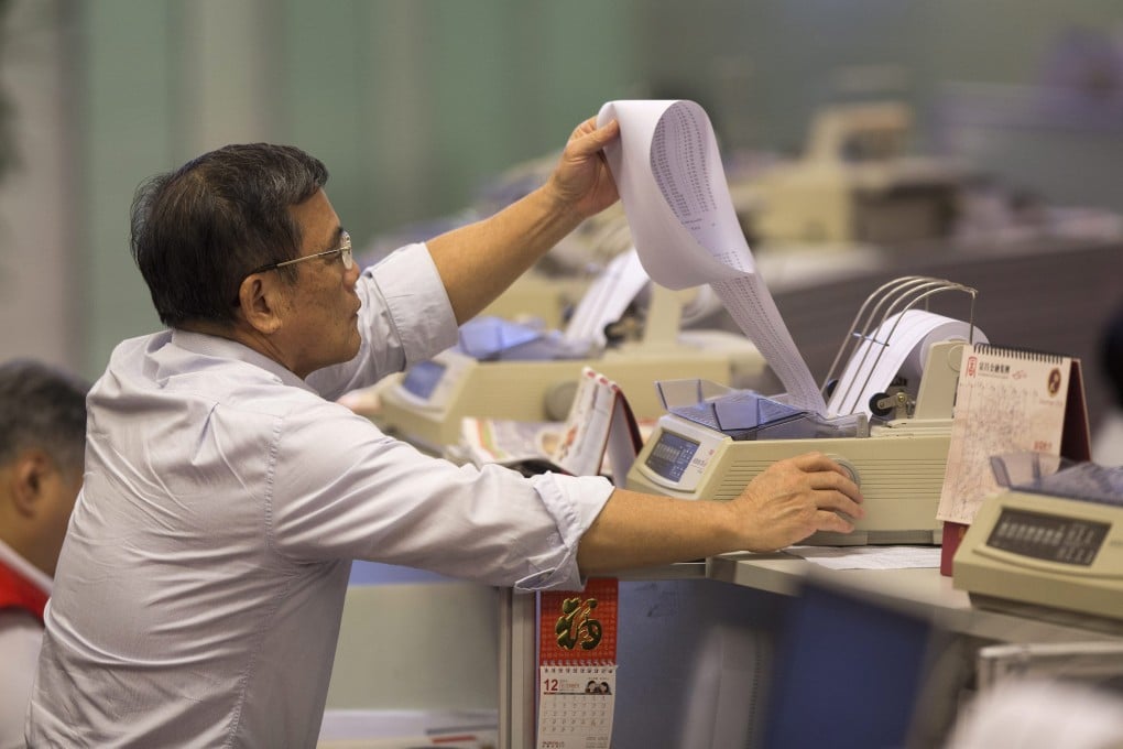 A stock broker prints a list of the day's transactions at Hong Kong Exchanges and Clearing. Photo: EPA