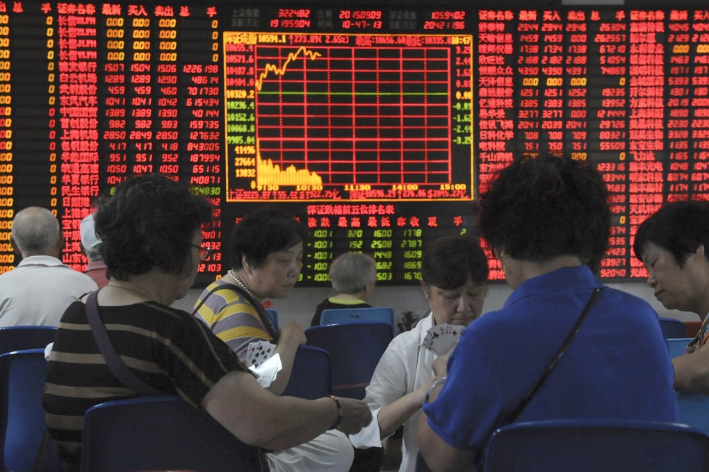 Investors play cards in front of an electronic board showing stock information at a brokerage house in Shanghai, China. Photo: Reuters