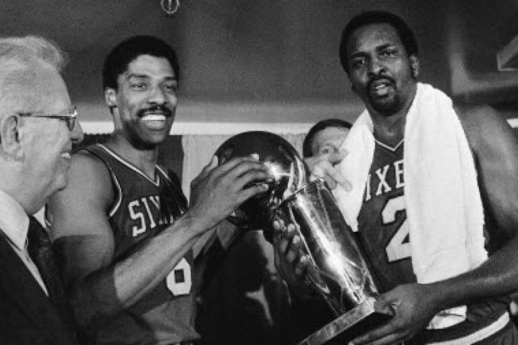 Moses Malone (right) and Julius Irving hold the NBA Championship trophy after the 76ers' triumph in 1983. Photos: AP
