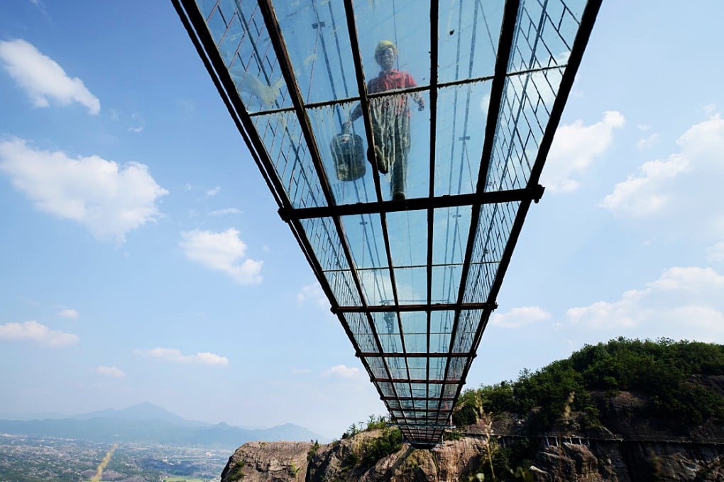 Workers at the Shiniuzhai National Geopark in Pingjiang county, Hunan province have been putting the finishing touches to a new bridge, by laying down its glass floor. Photo: CNS