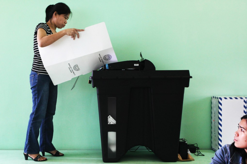 A Filipino voter casts her ballot in Hong Kong during the 2010 election.  The voting machine dispute is just the latest to sour Philippine-Chinese relations. Photo: AFP