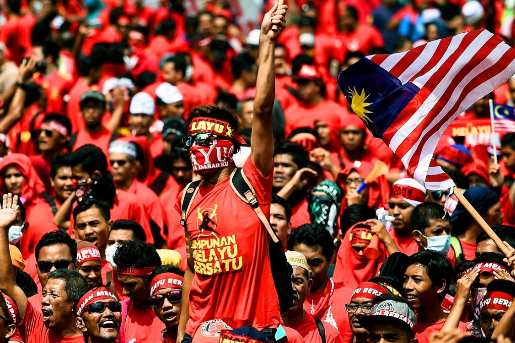 Pro-government ethnic Malay hardliners wave flags and shout slogans during a demonstration in Kuala Lumpur. Photo: AFP