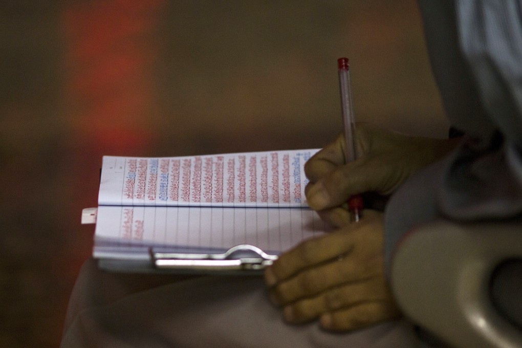 A Chinese investor records stock prices in a notebook at a brokerage in Beijing as Asian markets end trading for the day and wait for news early on Friday on whether the US Federal Reserve would up or stay put on interest rates. Photo: AP