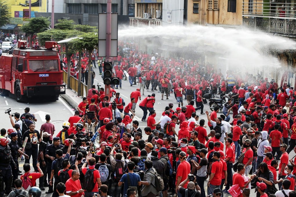 Riot police fires a water cannon to pro-government "red shirt" protesters as they try to enter China Town during a demonstration in Kuala Lumpur. Photo: EPA