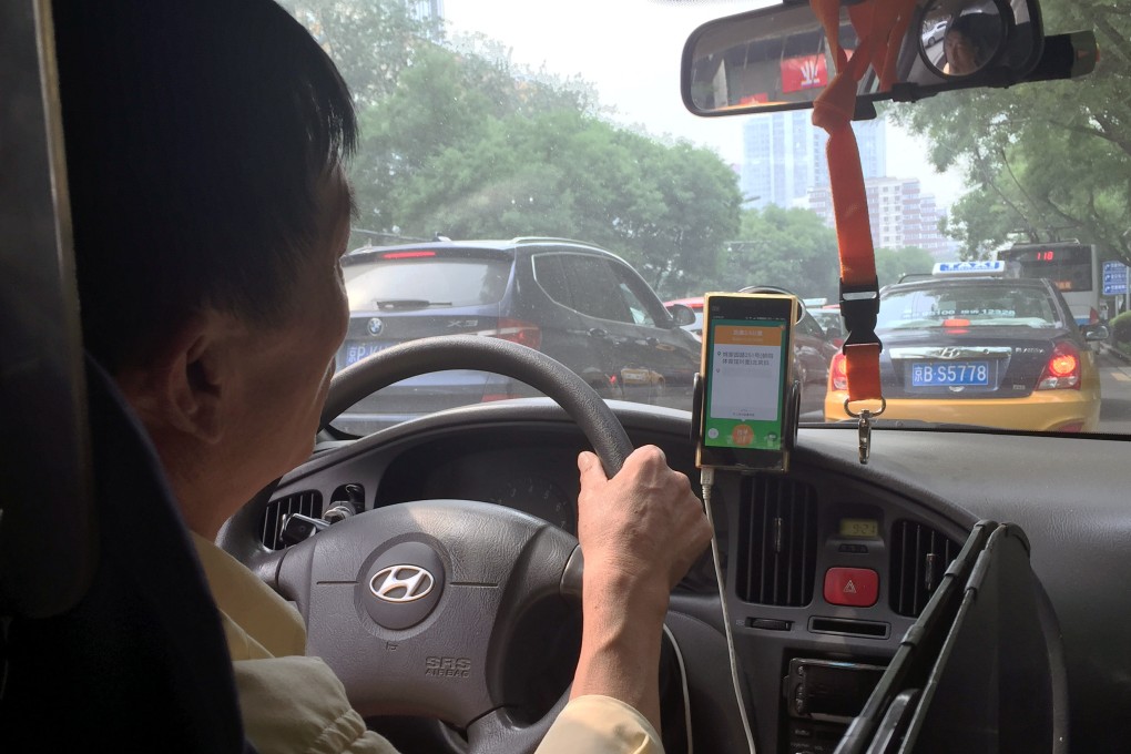 A taxi driver in Beijing takes a request from a taxi-hailing app. Now the Chinese government seems to be muscling on such apps by creating their own. Photo: Simon Song
