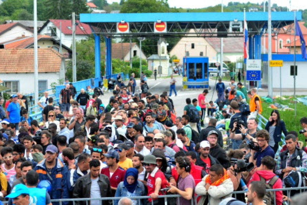 Migrants crowd the border crossing between Rigonce in Slovenia and Hamica in Croatia today. Photo: EPA
