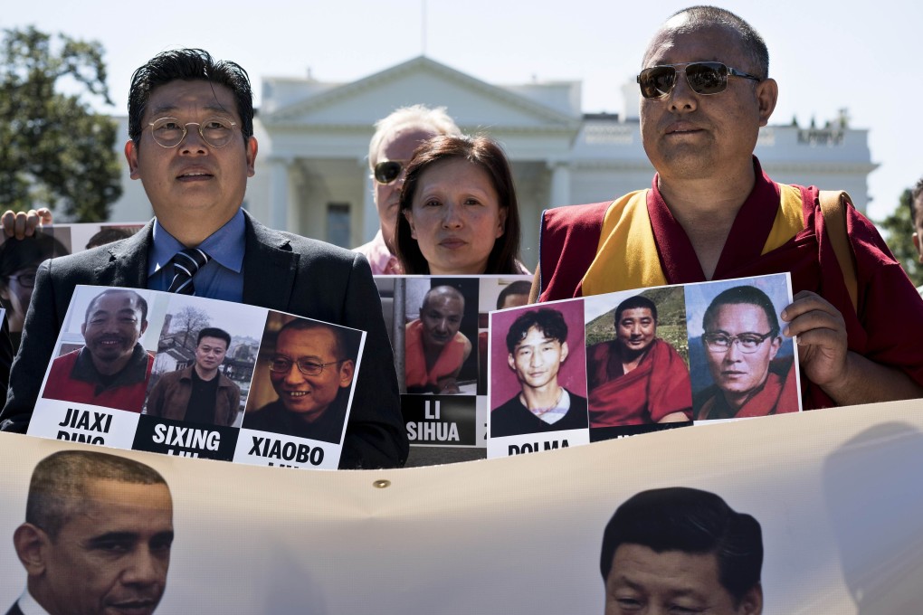 People hold up photos of alleged victims of persecution during a protest in front of the White House ahead of the upcoming state visit of Chinese President Xi Jinping. Photo: AFP