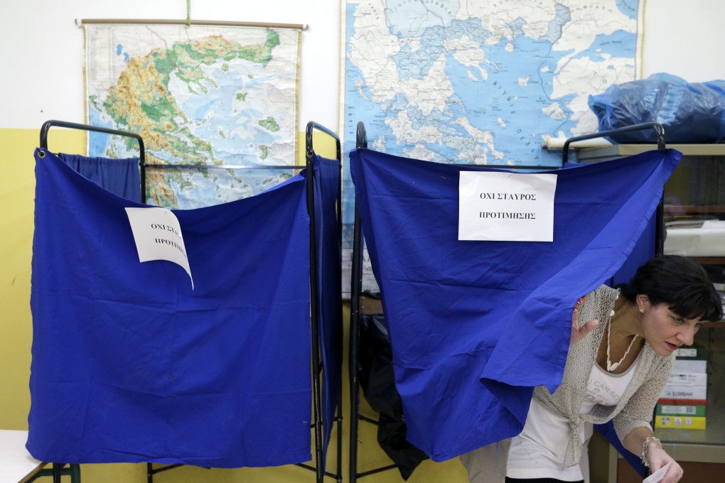 A woman casts her vote at a polling station in Athens. Greeks were voting Sunday in their third national polls this year, called on to choose who they trust to steer the country into its new international bailout. Photo: AP