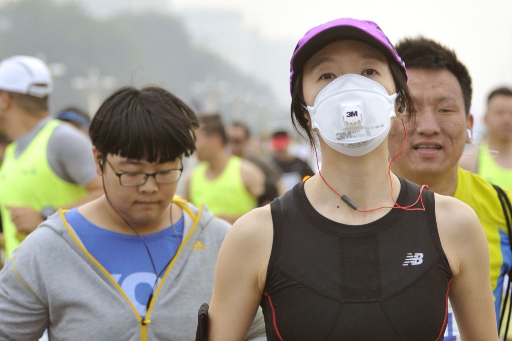 Runners take part in the 2015 Beijing Marathon, with some wearing masks because of air pollution. Photo: Kyodo