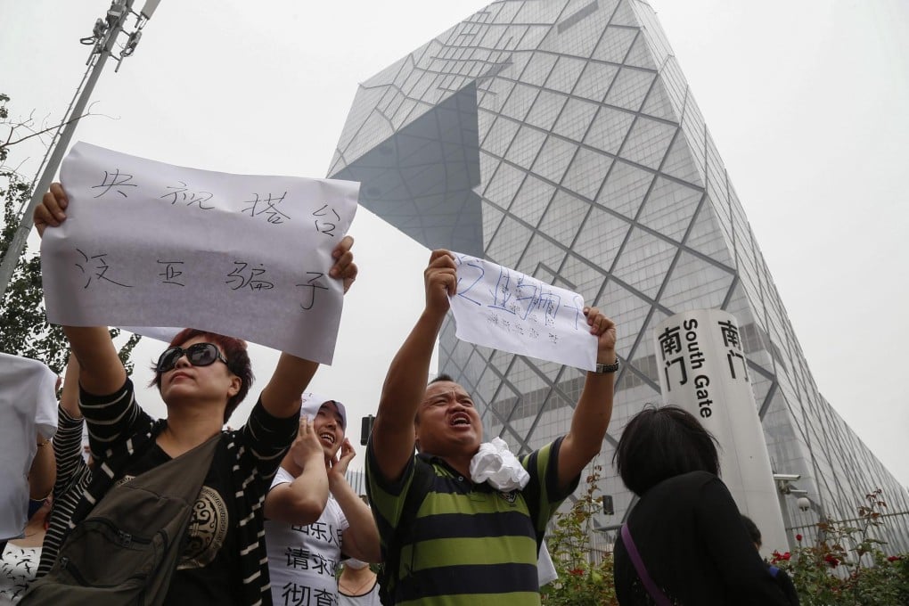 Investors protest outside the CCTV Tower in Beijing yesterday. They called for a government investigation into the Fanya exchange. Photo: EPA