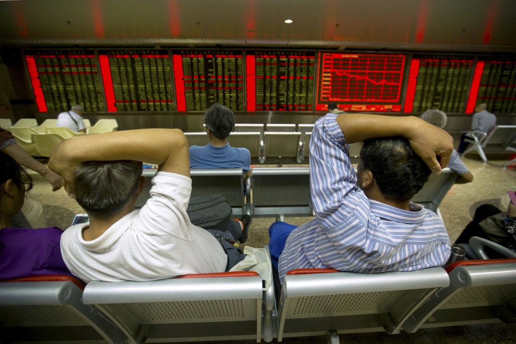A pair of investors lean away from each other while monitoring stock prices in China's volatile markets. Photo: AP