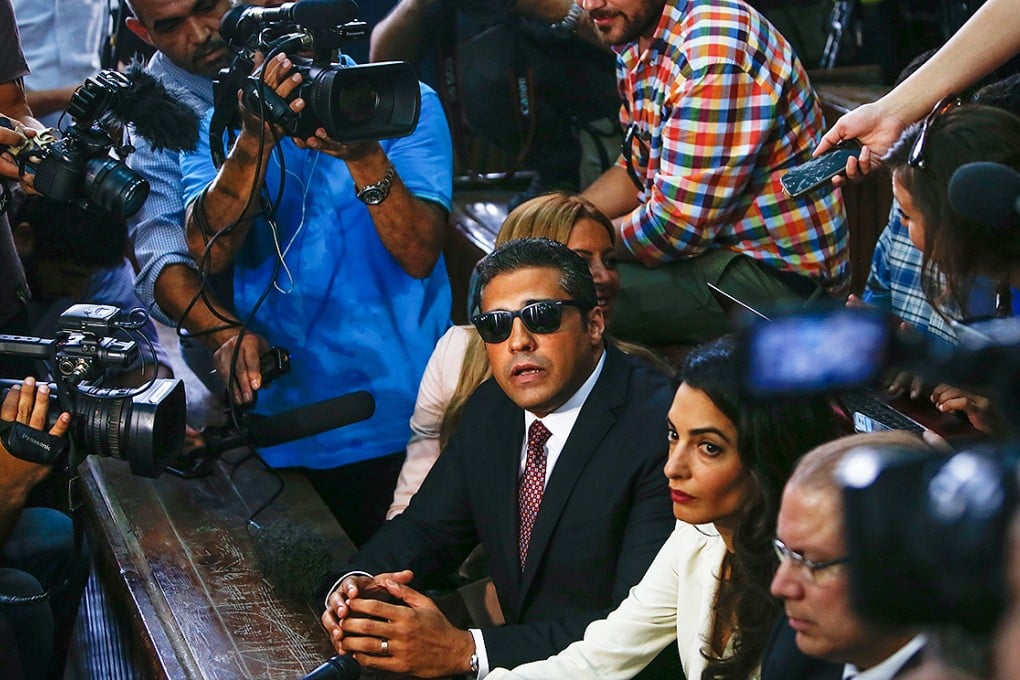 Al Jazeera journalist Mohammed Fahmy talks to the press ahead of his verdict at a courtroom in Cairo flanked by his wife Marwa and human rights lawyer Amal Clooney (foreground) . Photo: Xinhua