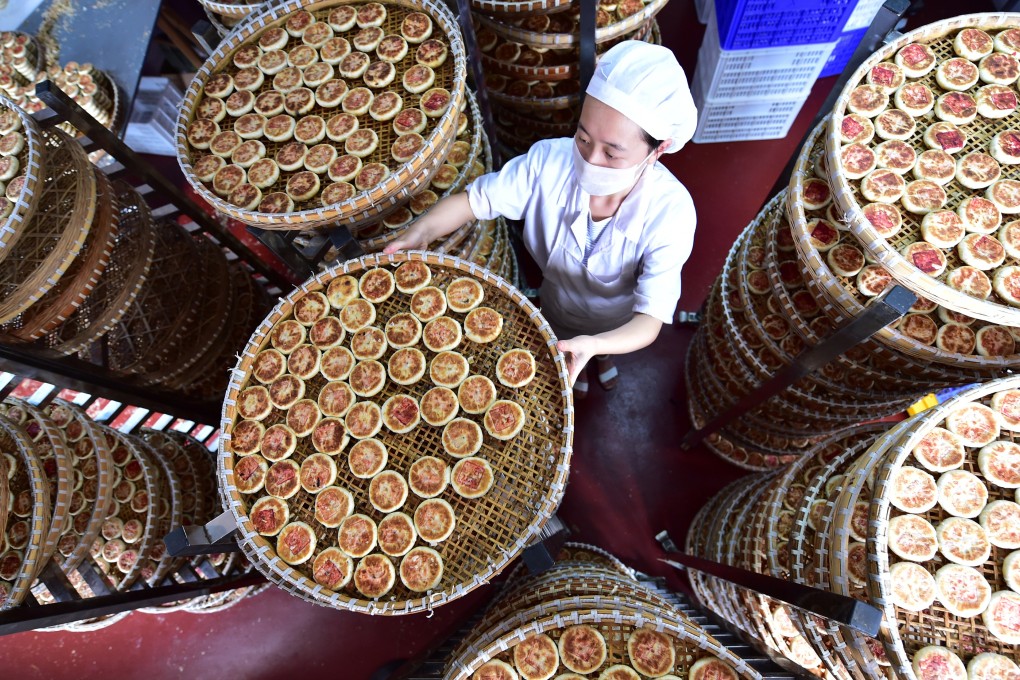 A worker at Yiting Supply and Marketing Cooperatives Food Factory lets baked mooncakes cool. Photo: Xinhua