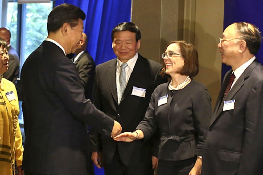 Chinese President Xi Jinping greets Oregon Governor Kate Brown ahead of meeting with five US governors where they signed on cooperation on use of clean-tech businesses. Photo: AFP
