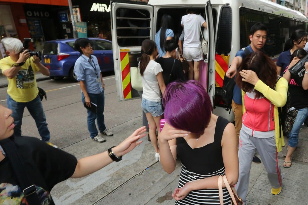Police and immigration officers arresting suspected prostitutes from the mainland in raids on hotels. Photo: Felix Wong