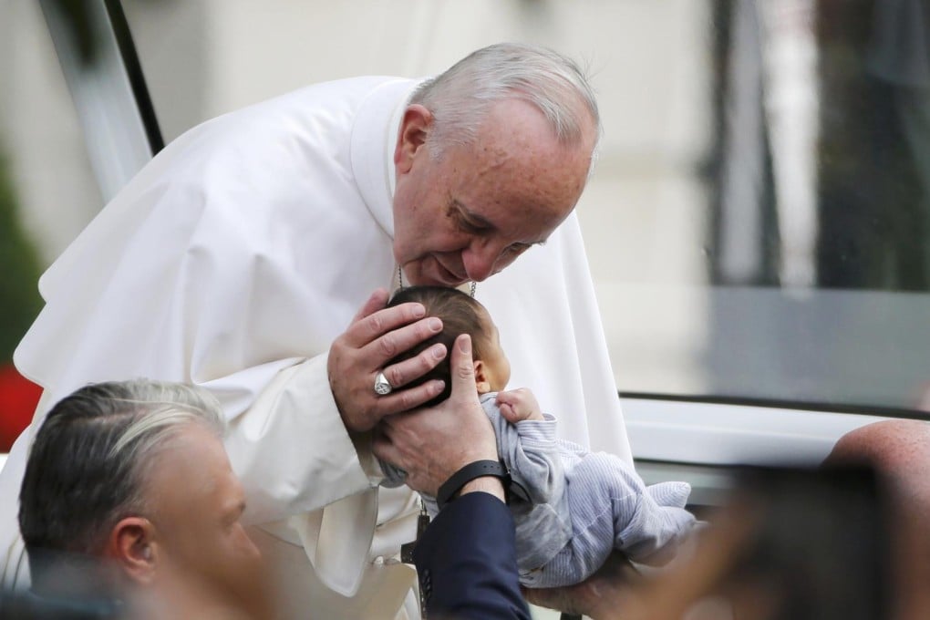 Pope Francis kisses a child as he arrives at Independence Mall in Philadelphia, Pennsylvania, to deliver a speech. Photo: Reuters