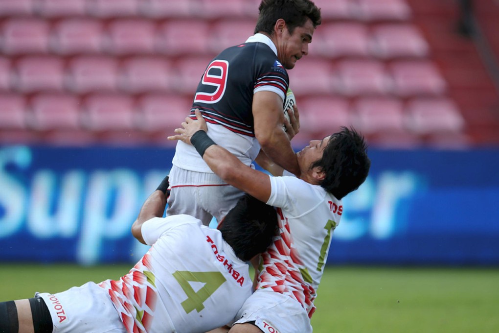 Hong Kong's Rowan Varty is tackled by a pair of Japanese players in their Cup semi-final at the Thailand Sevens. Photos: Asia Rugby